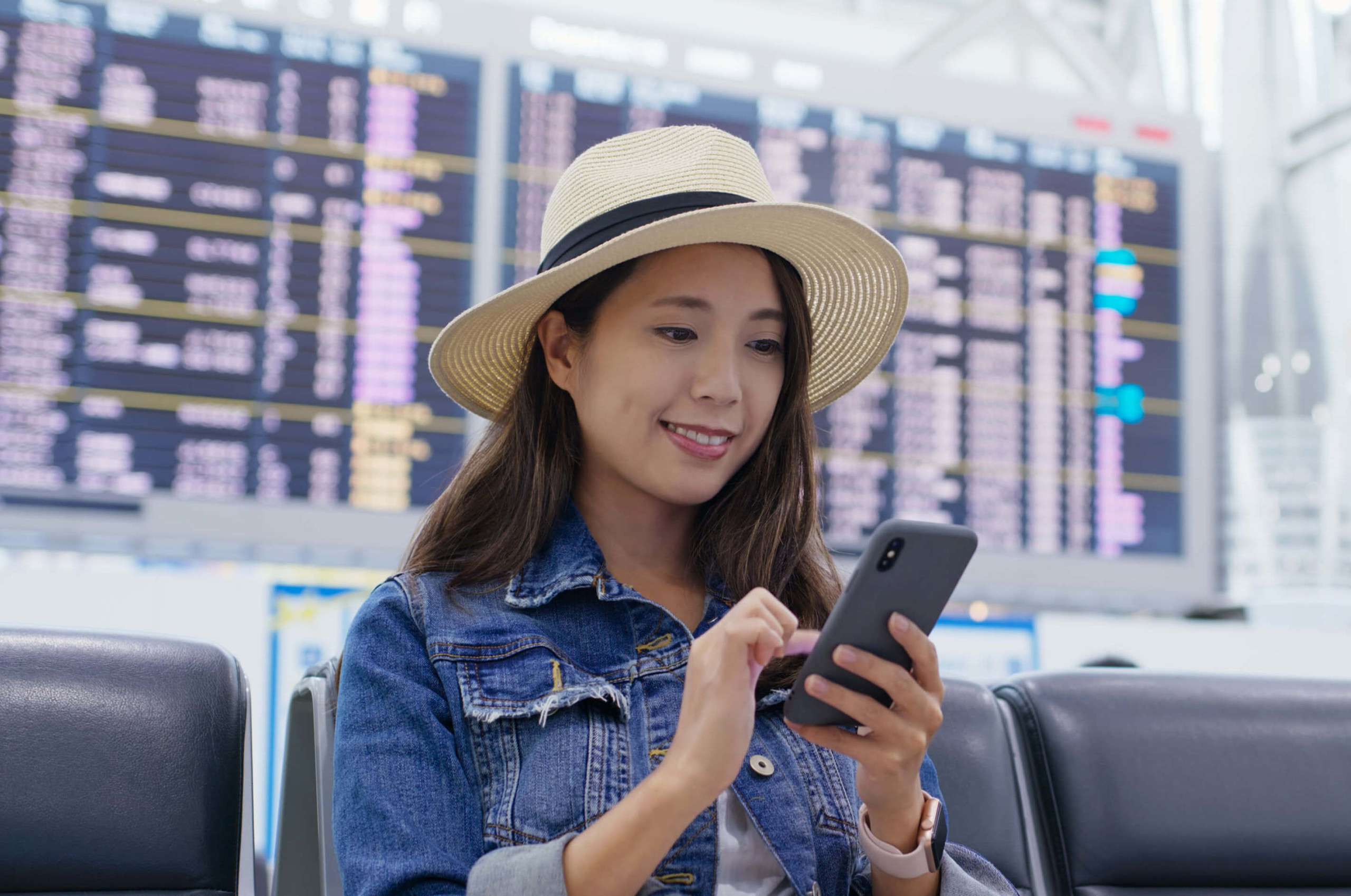 Woman in airport using VeriFLY on her smartphone
